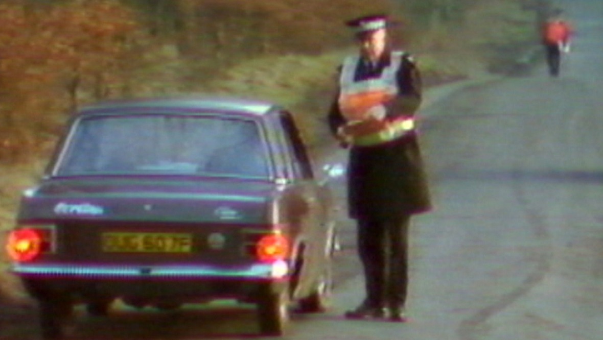 A police officer speaks to a passing driver during the murder investigation.