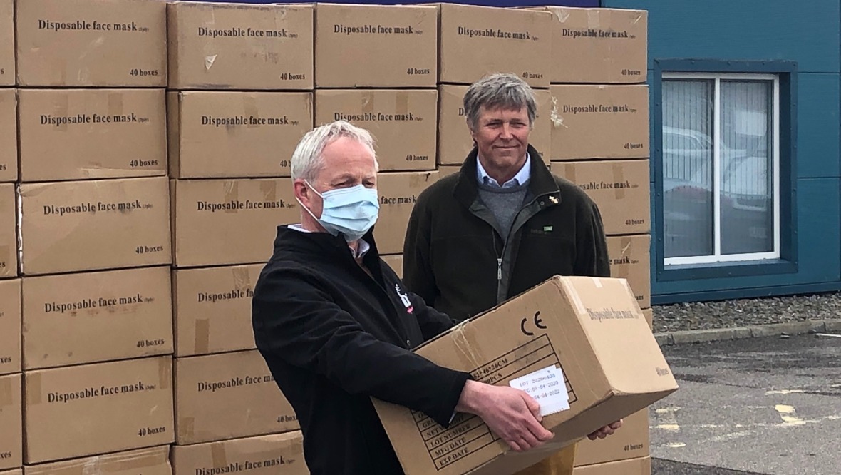 Tory MSP Edward Mountain (right) delivers the face masks to Campbell Mair from HHC.