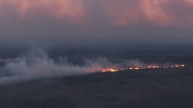 Firefighters battle massive blaze on hills near reservoir