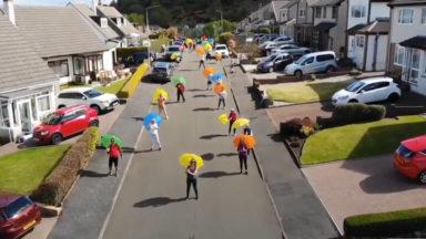Having a broll: Neighbours take part in umbrella flash mob