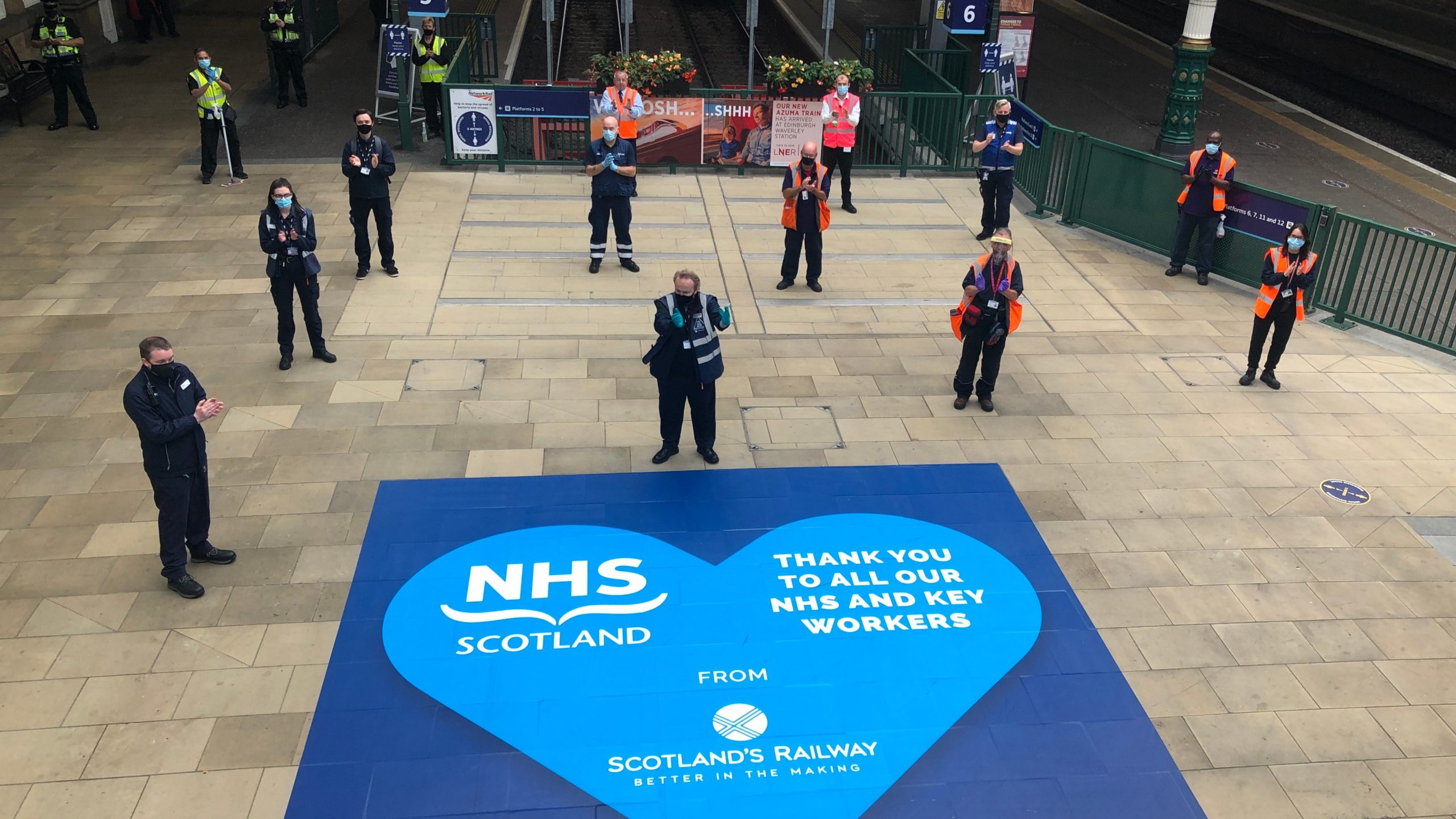 Workers at Edinburgh Waverley applauding.