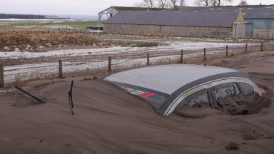 Vehicles buried under huge mounds of muddy snow