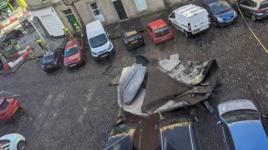 Roof blows off flats and crashes into parked cars