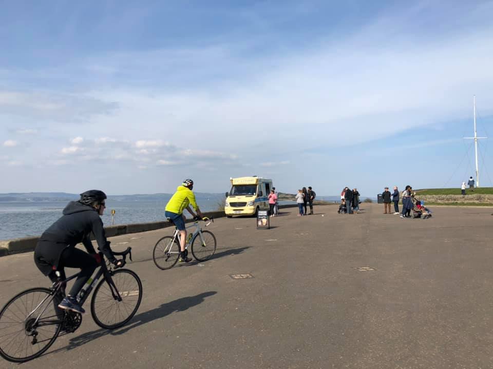 Cyclists pass a queue at an ice-cream van in Cramond, north-west of Edinburgh.