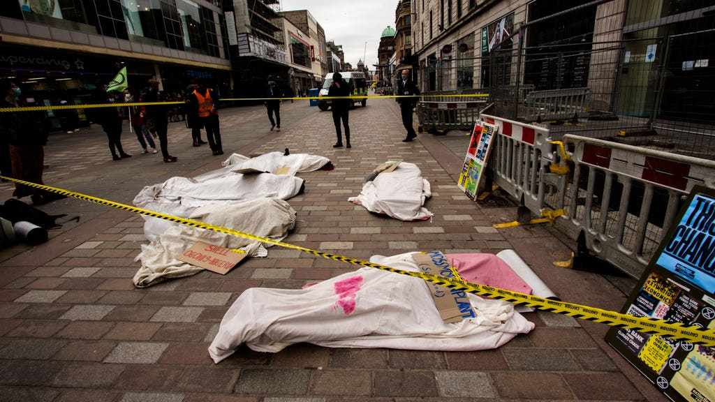 Activists pose as dead bodies in protest against Barclays