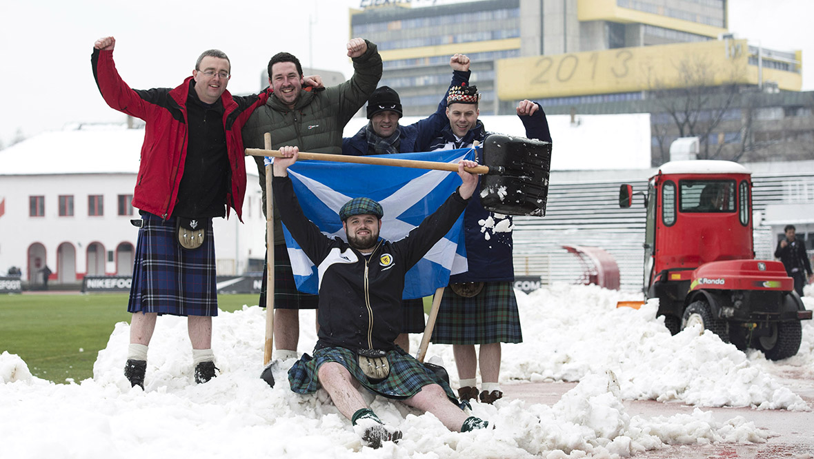 Scotland fans help to clear snow from the pitch ahead of their side taking on Serbia in a 2014 World Cup qualifier.