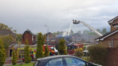 Firefighters remain at scene after houses engulfed in flames