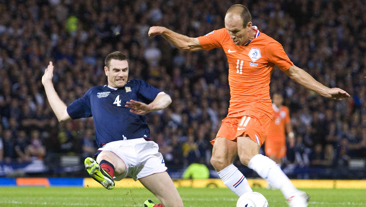 Stephen McManus slides in on Arjen Robben at Hampden.