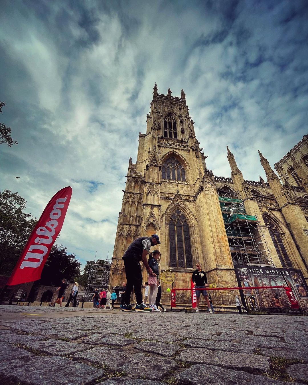 The team get people to play a game of tennis outside York Minster cathedral.