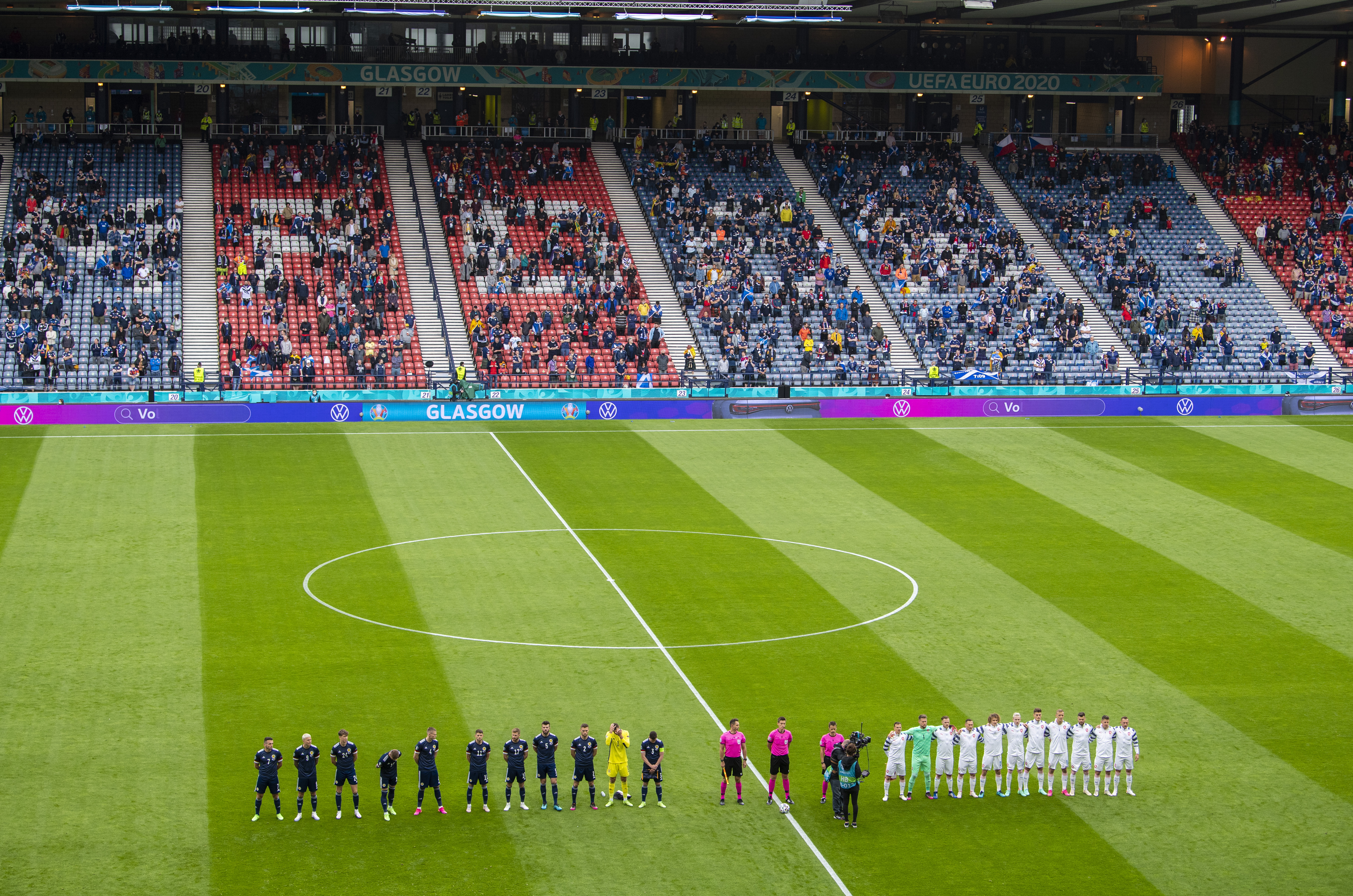 The teams line up for the pre-match national anthems.