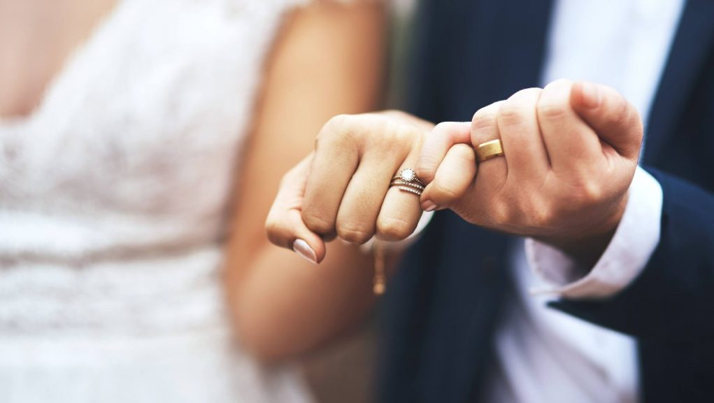 a-man-and-woman-holding-hands-making-a-heart-shape-with-the-words-one