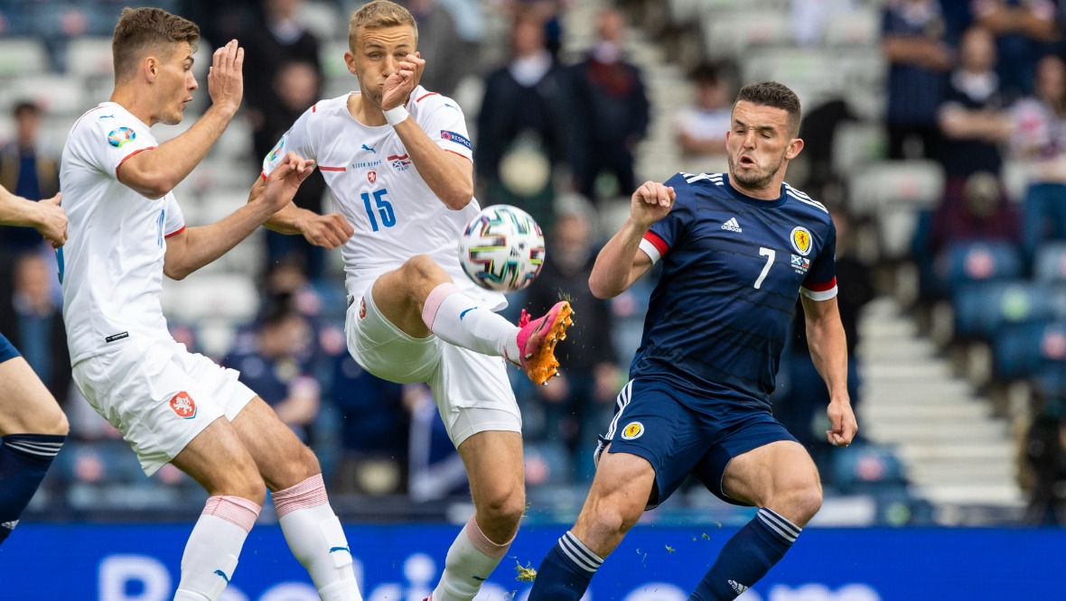 John McGinn battles for possession.