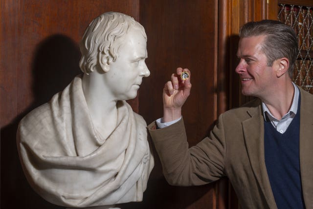 Matthew Maxwell Scott, a descendent of the writer, with the coin. (Phil Wilkinson/Royal Mint/PA)<br>” /><span class=