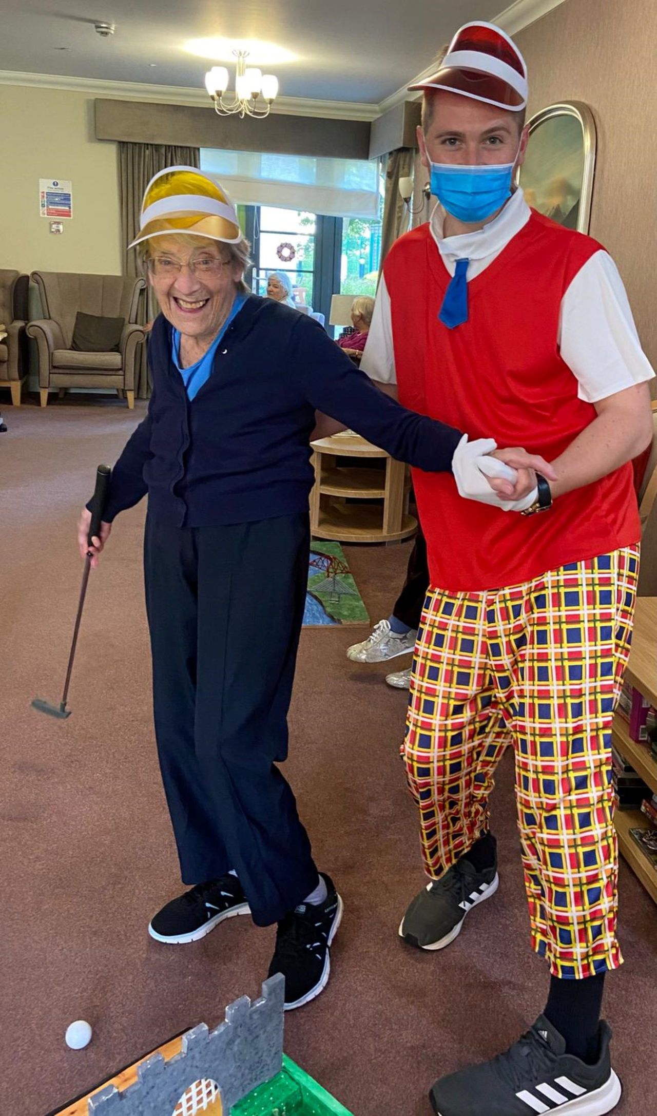 Care home resident June enjoys a round of crazy gold with Callum Arnott.