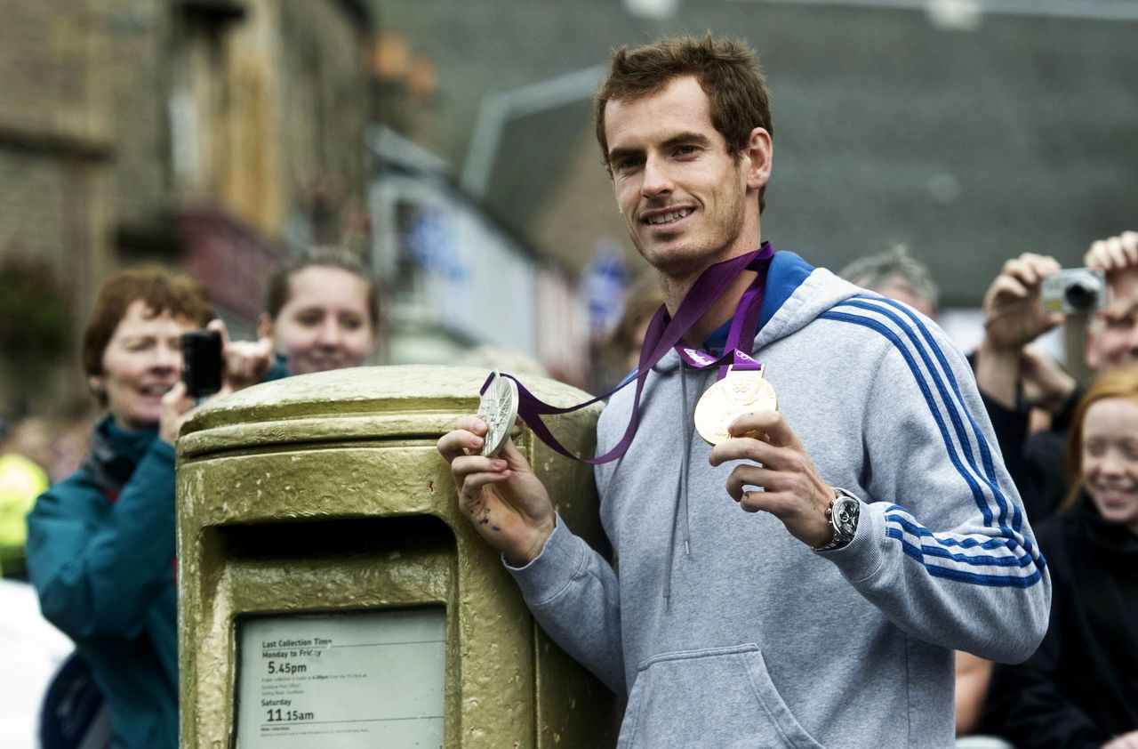 Andy Murray poses with his gold medal at the post box sprayed in his honour.
