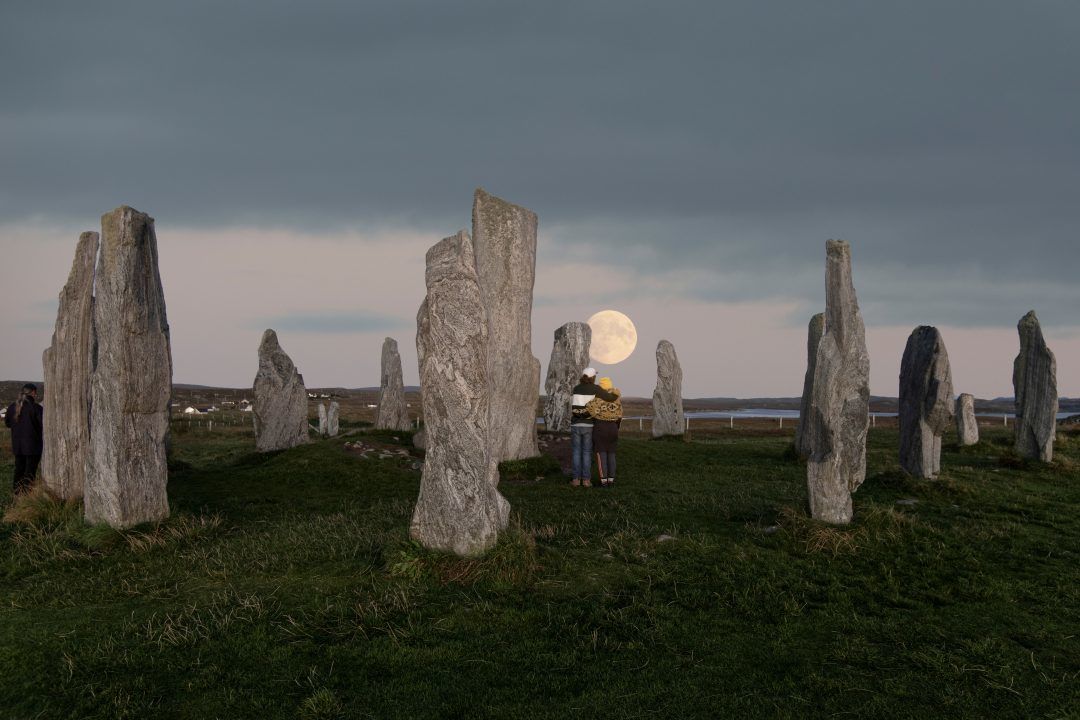 Photo captures couple gazing at full moon over ancient stone circle