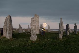 Photo captures couple gazing at full moon over ancient stone circle