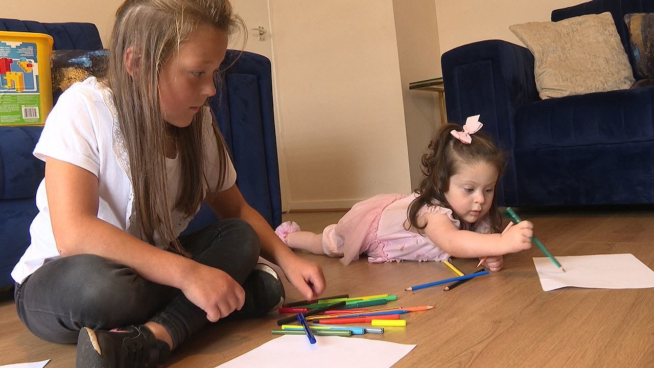 Eight-year-old Laila MacRae draws rainbows with her sister Amber.