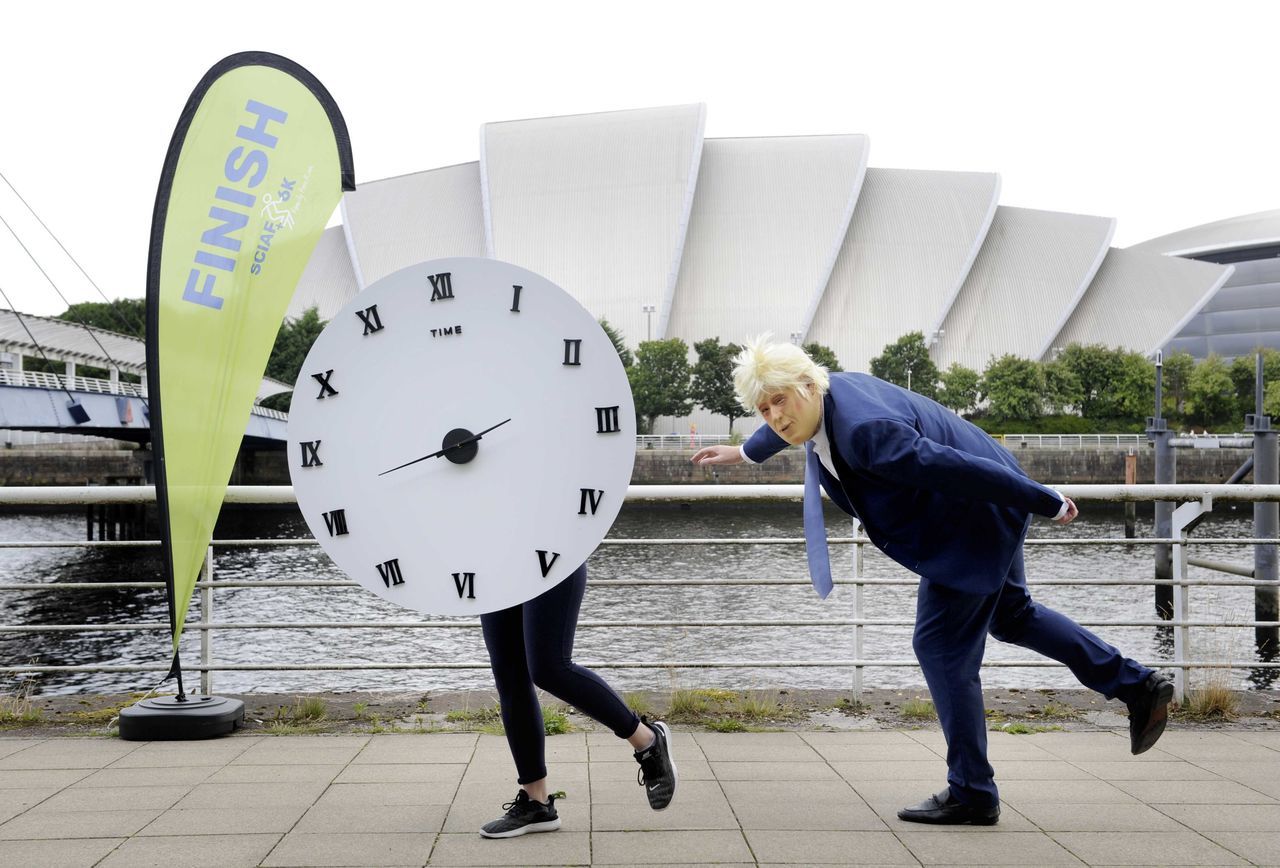 A campaigner dressed as Boris Johnson races against a 'clock'.