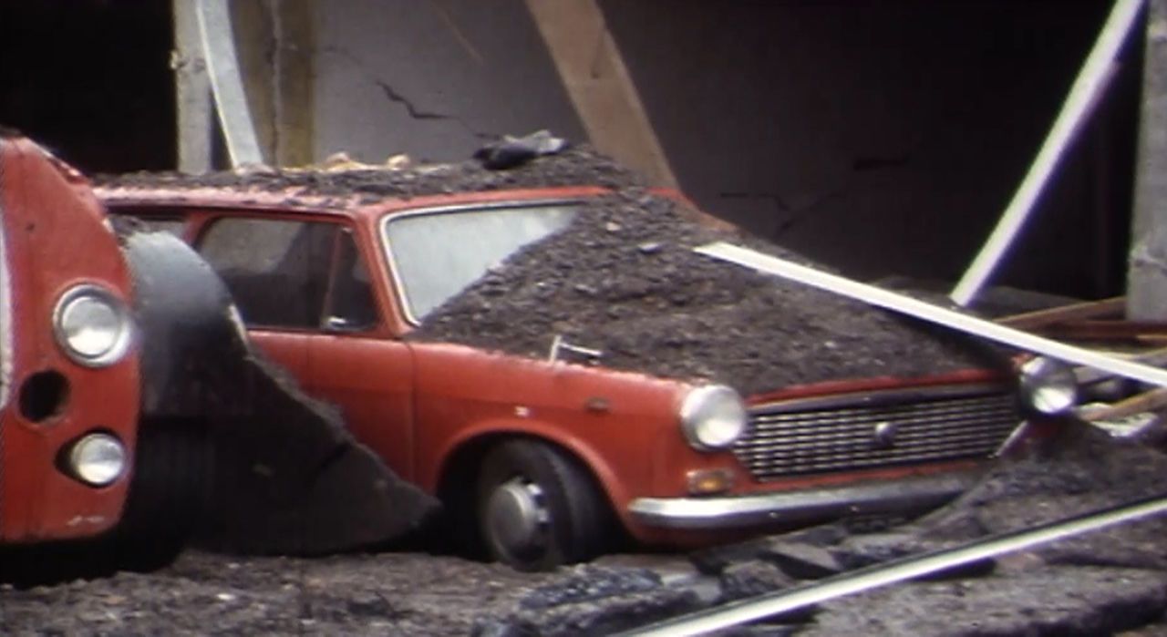 This car was left covered in rubble following the blast.