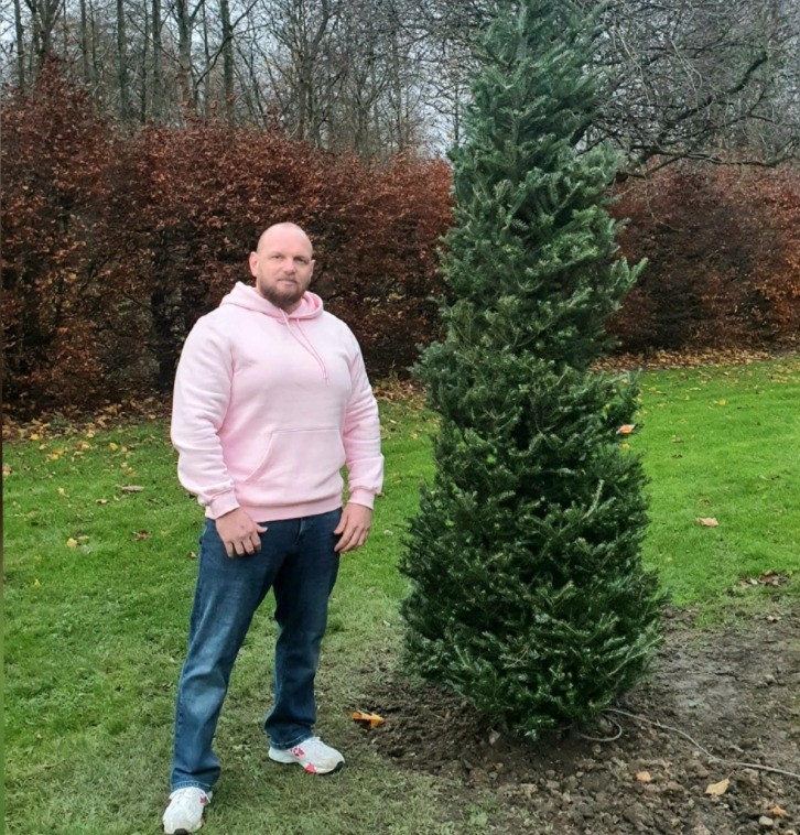 Councillor Darren Watt pictured alongside one of the trees.