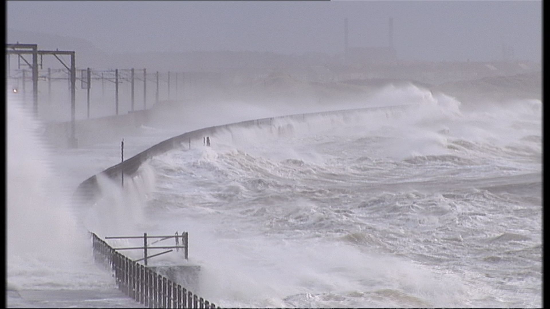 Waves crashed against the rail network and power lines.