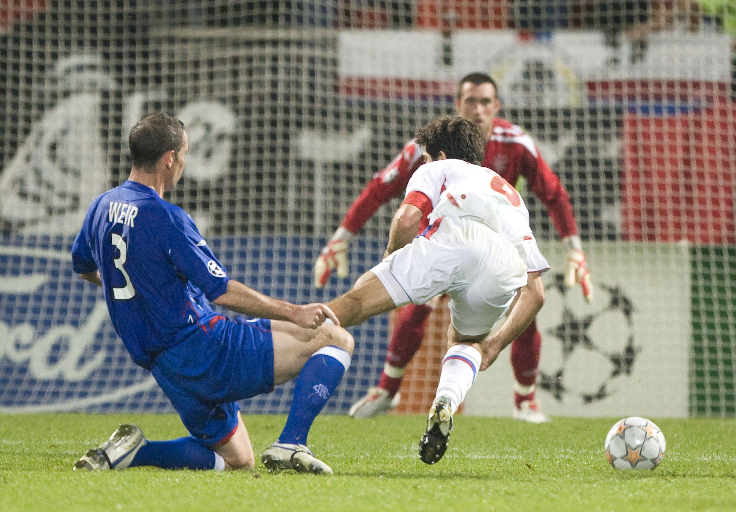 Juninho goes down under a tackle from Rangers defender David Weir.