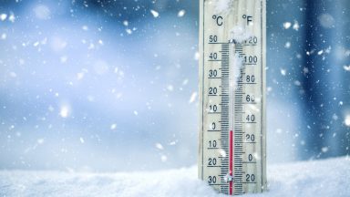 Stock image of a thermometer on snow showing a low temperature.