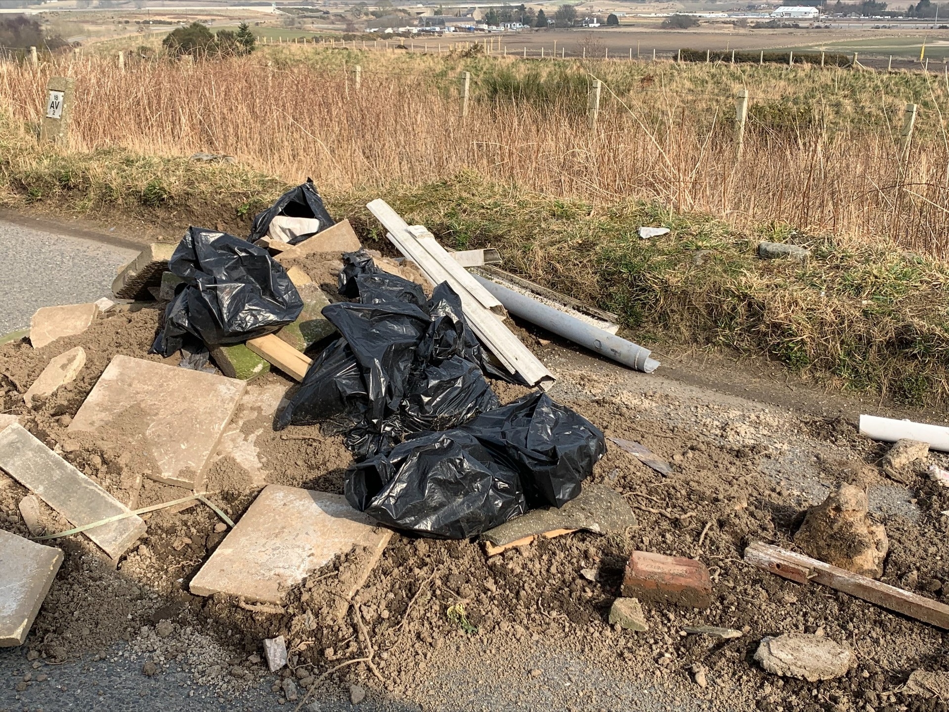 The rubbish included paving slabs, building rubble, black bin bags, and dirt.