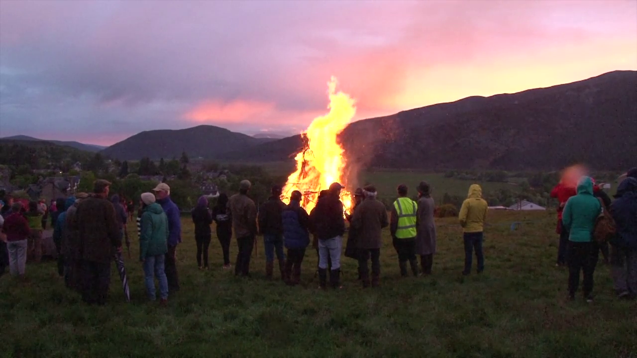 People gather around a bonfire in Braemar.