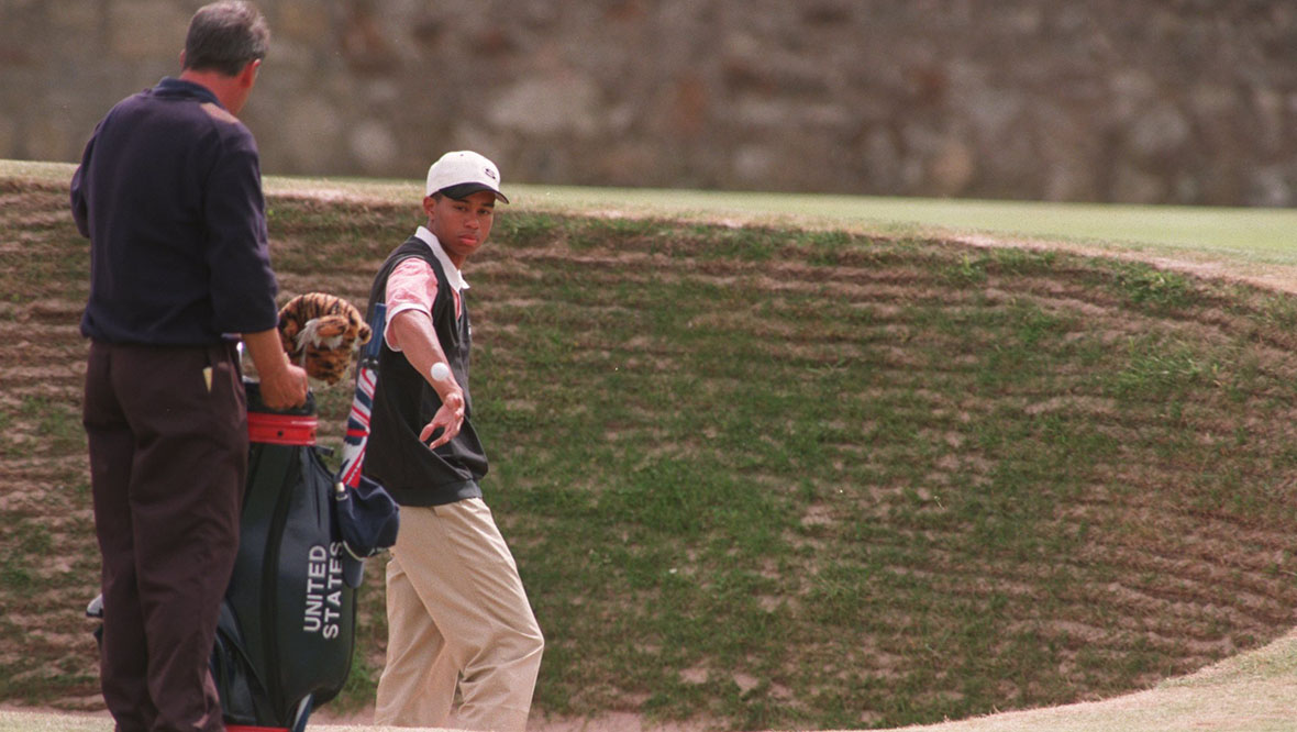 Woods catching a ball from his caddie during a practice round at St Andrews in 1995