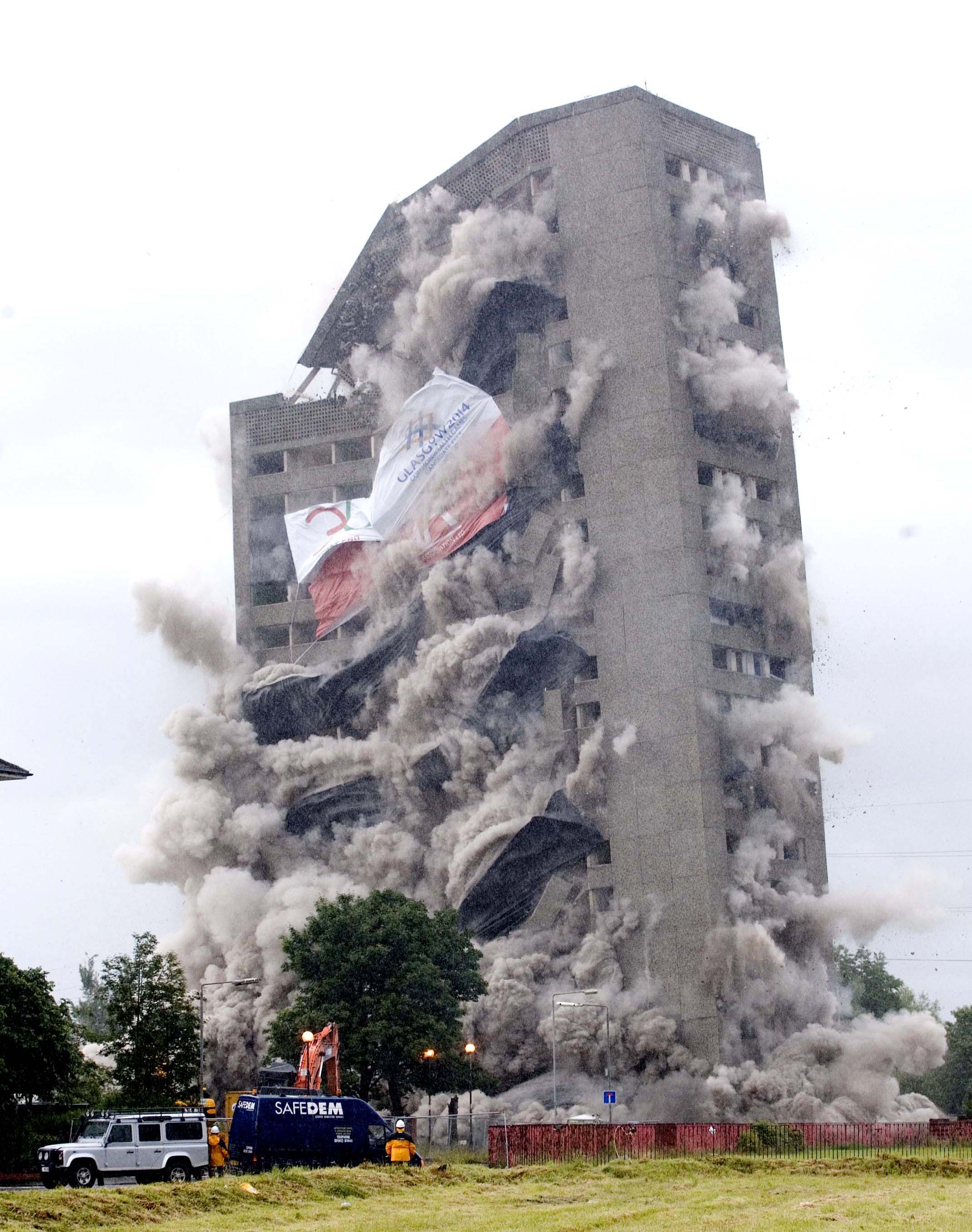 A block of flats is blown up to make way for the athletes' village.