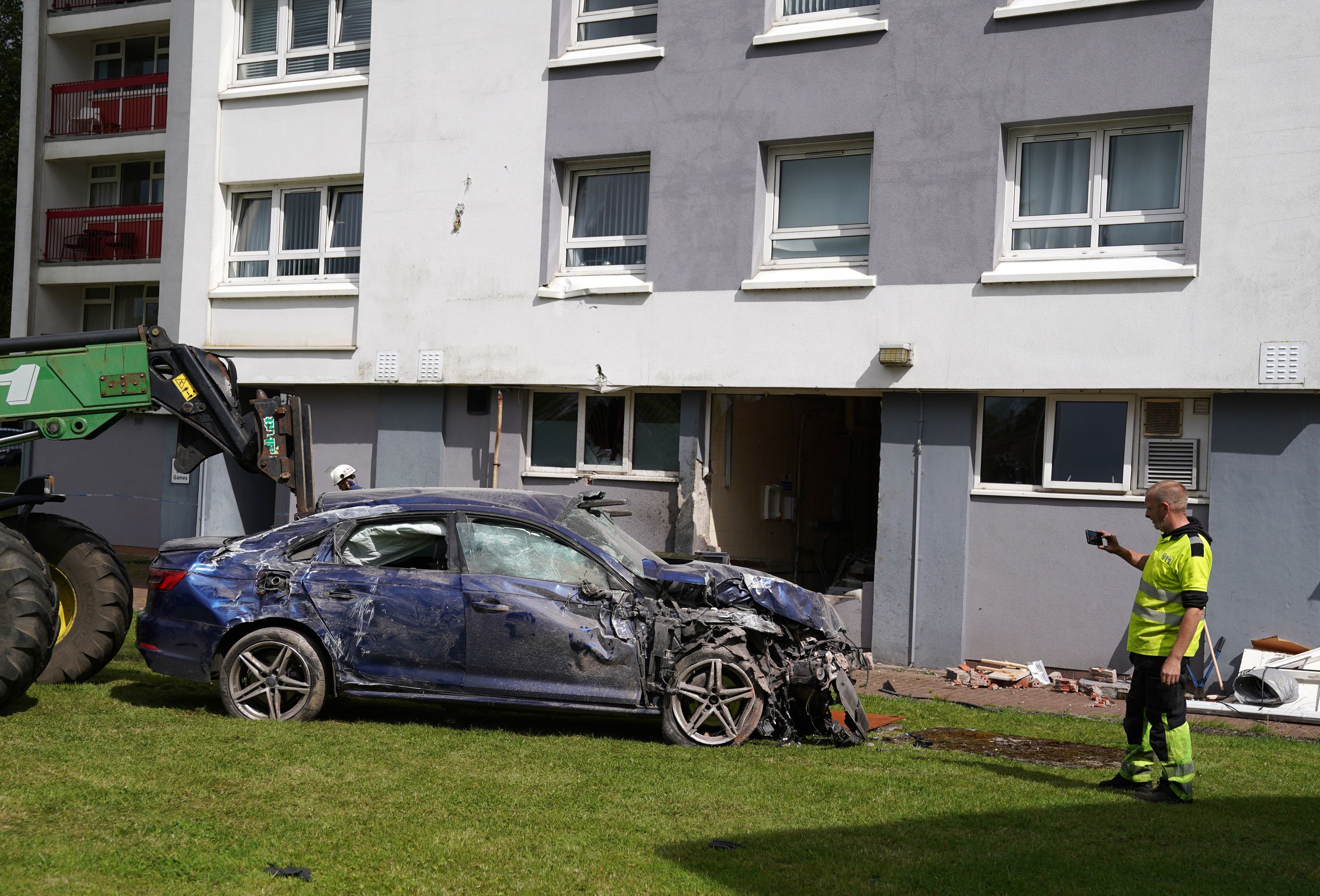 Firefighters inspect the scene of the crash at the flats in Paisley.