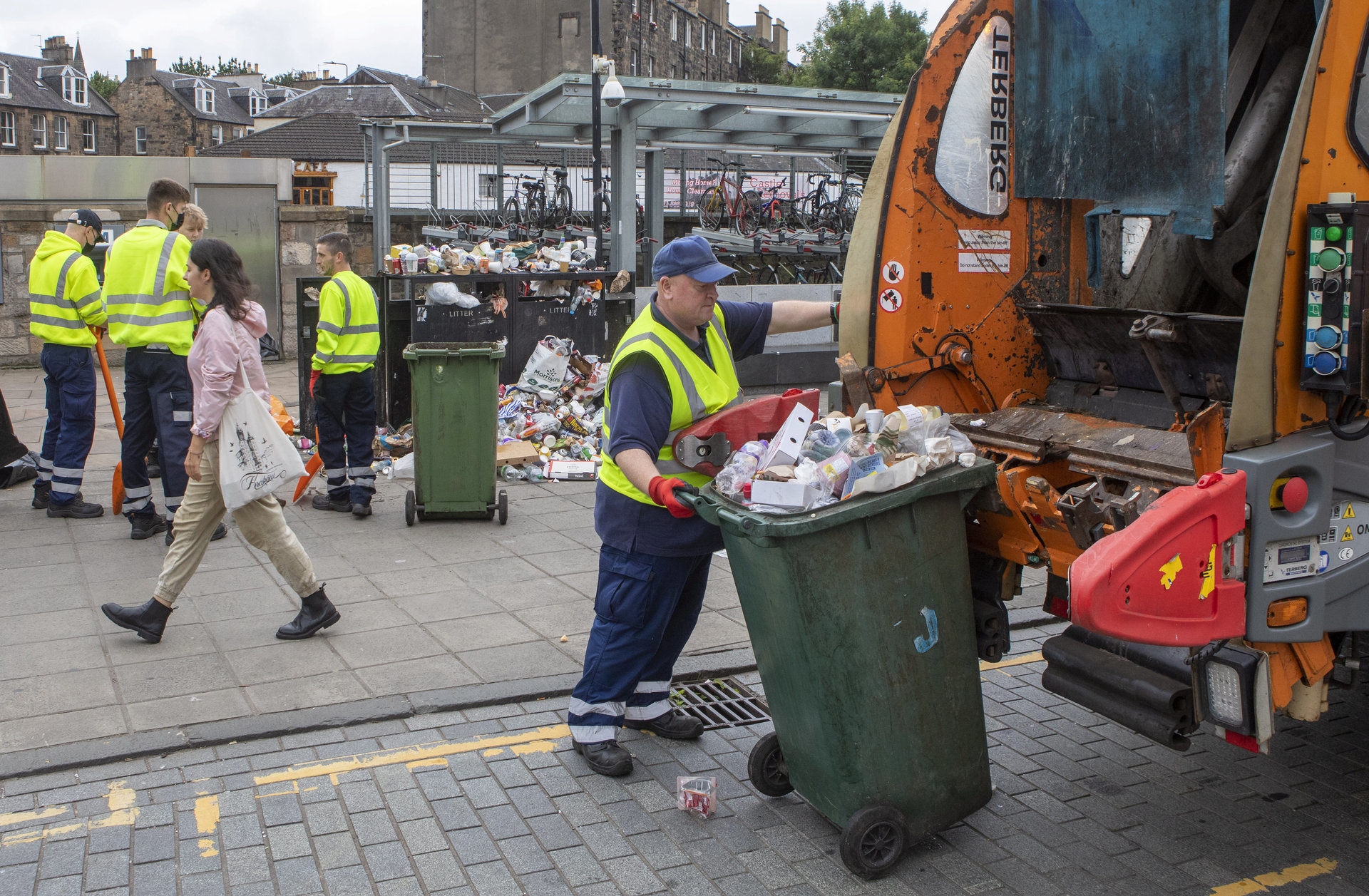 Bin workers begin to clean up overflowing bins and rubbish on Edinburgh's streets after the 12 day bin strike ends.