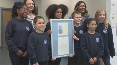 Primary school pupils receive one of the final letters from the Queen