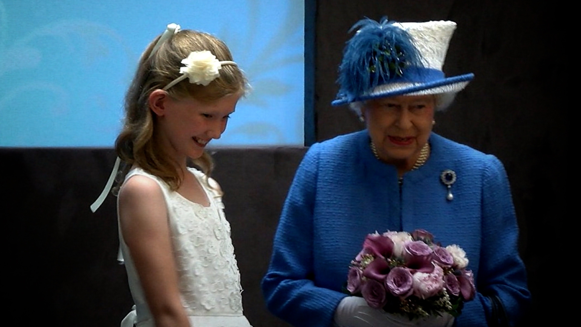 Amy gives flowers to the Queen