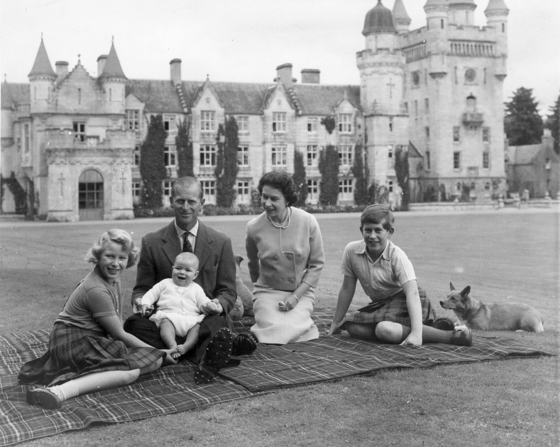 Queen Elizabeth II and Prince Philip with their children, Prince Andrew (centre), Princess Anne (left) and Charles on a picnic rug outside Balmoral Castle.