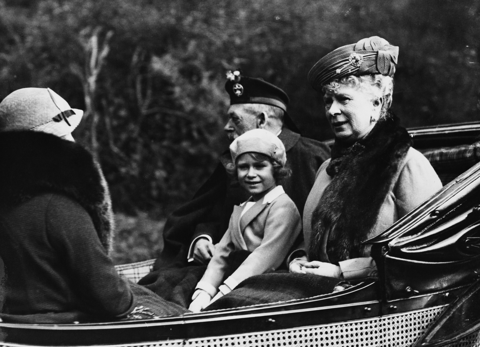 Princess Elizabeth seated between her grandfather King George V and grandmother Queen Mary of Teck  as they ride in a carriage back to Balmoral Castle from Crathie Kirk near Braemar in Scotland in August 1935.