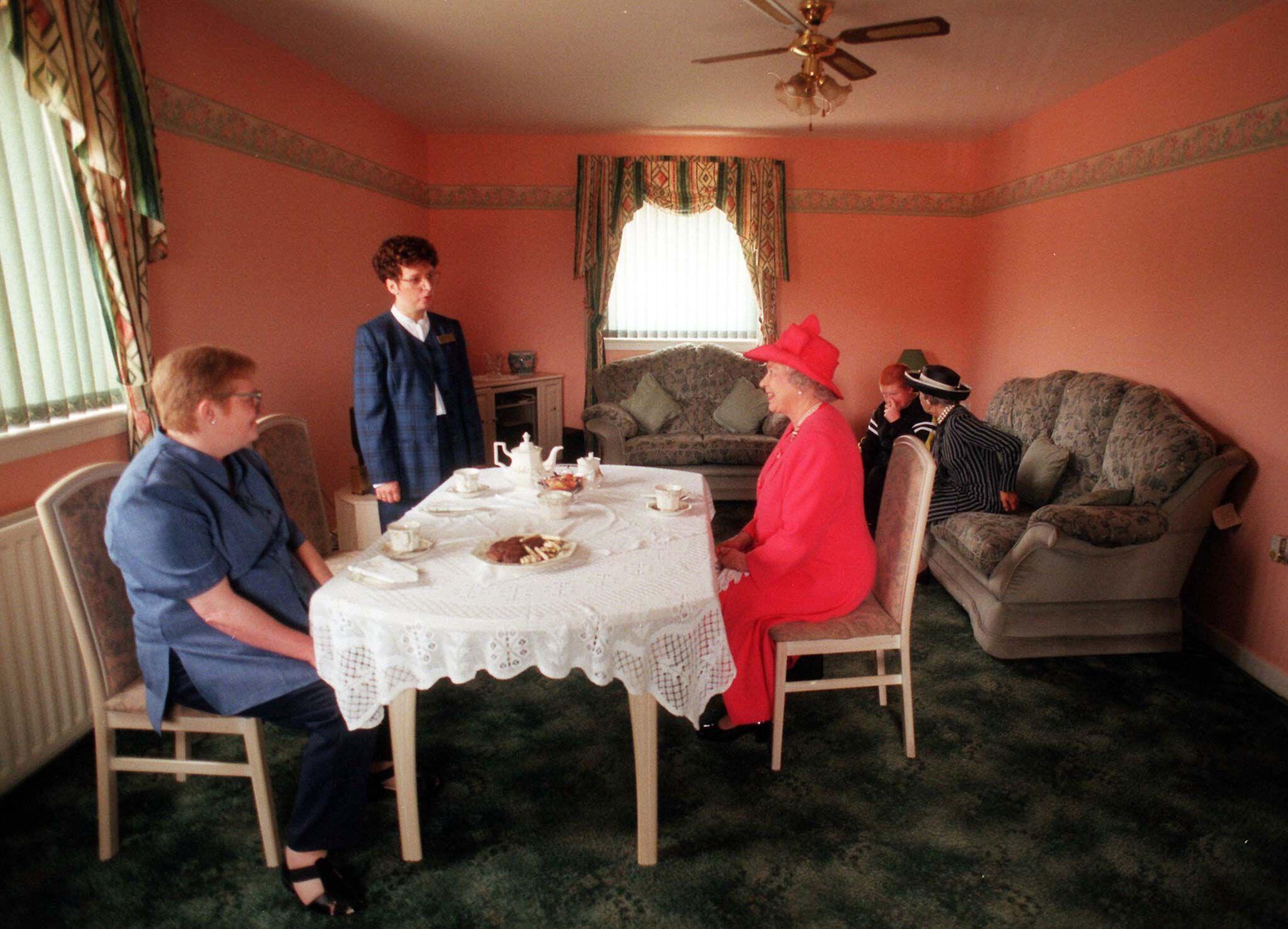 The Queen has tea with Susan McCarron (front left), her ten-year-old son James and housing manager Liz McGinniss, during a visit to Castlemilk in 1999.