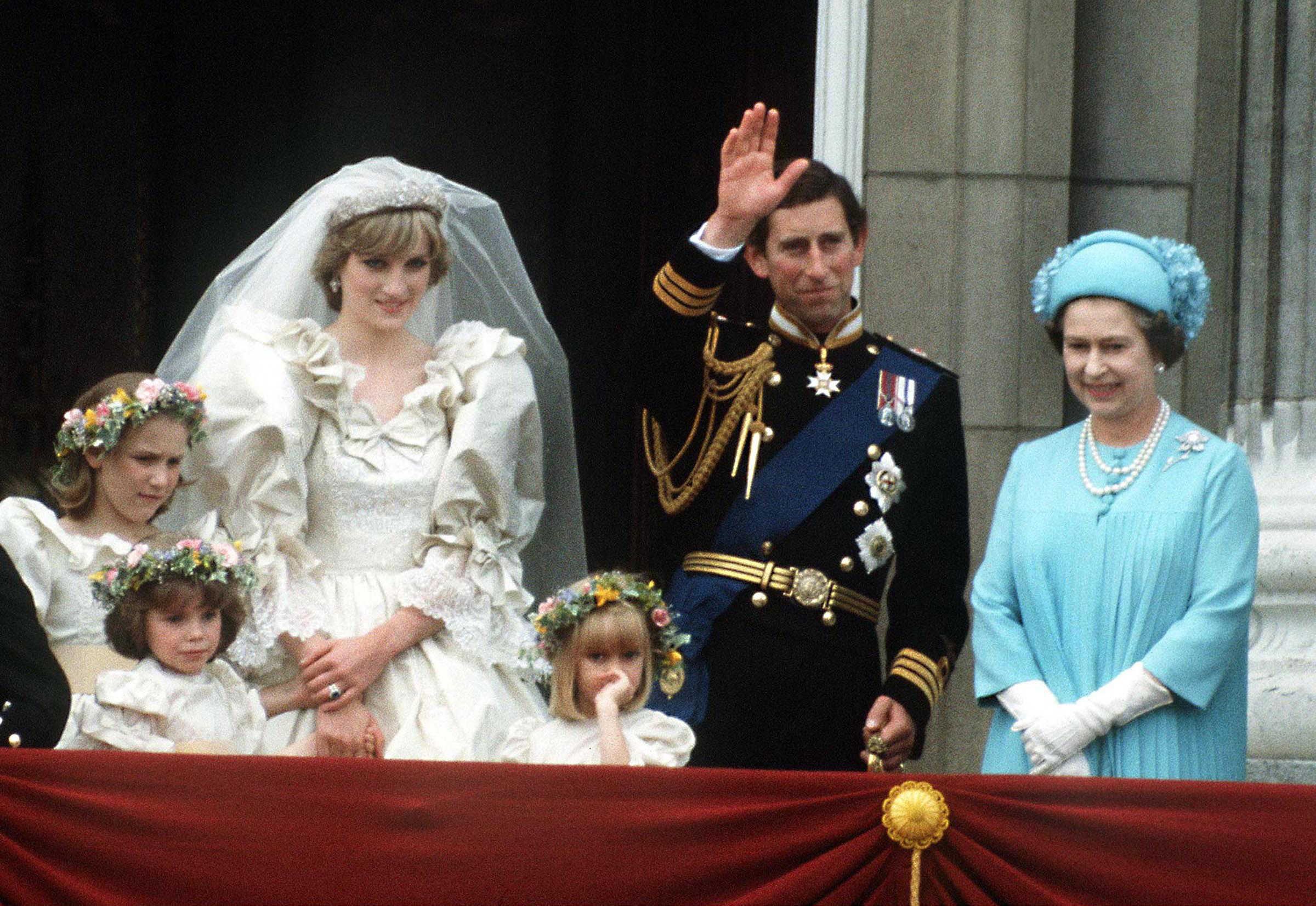 The Prince and Princess of Wales pose on the balcony of Buckingham Palace on their wedding day, with the Queen and some of the bridesmaids.