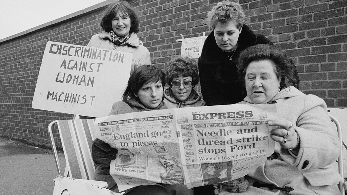 Women reading the Daily Express while striking outside Ford Dagenham, London, UK, 21st November 1984. 