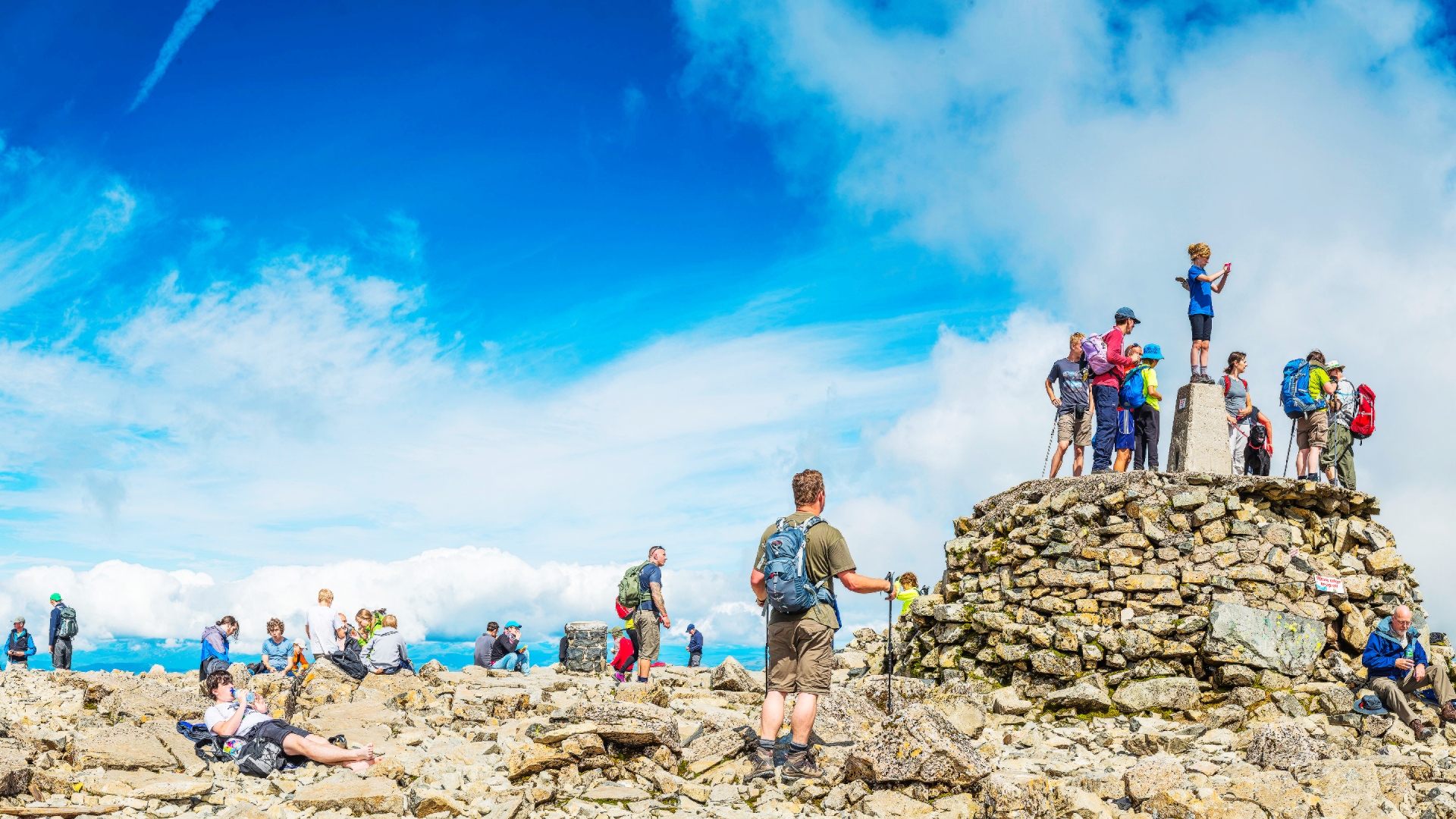 Crowds of hikers enjoying the summer sunshine on the summit of Ben Nevis.