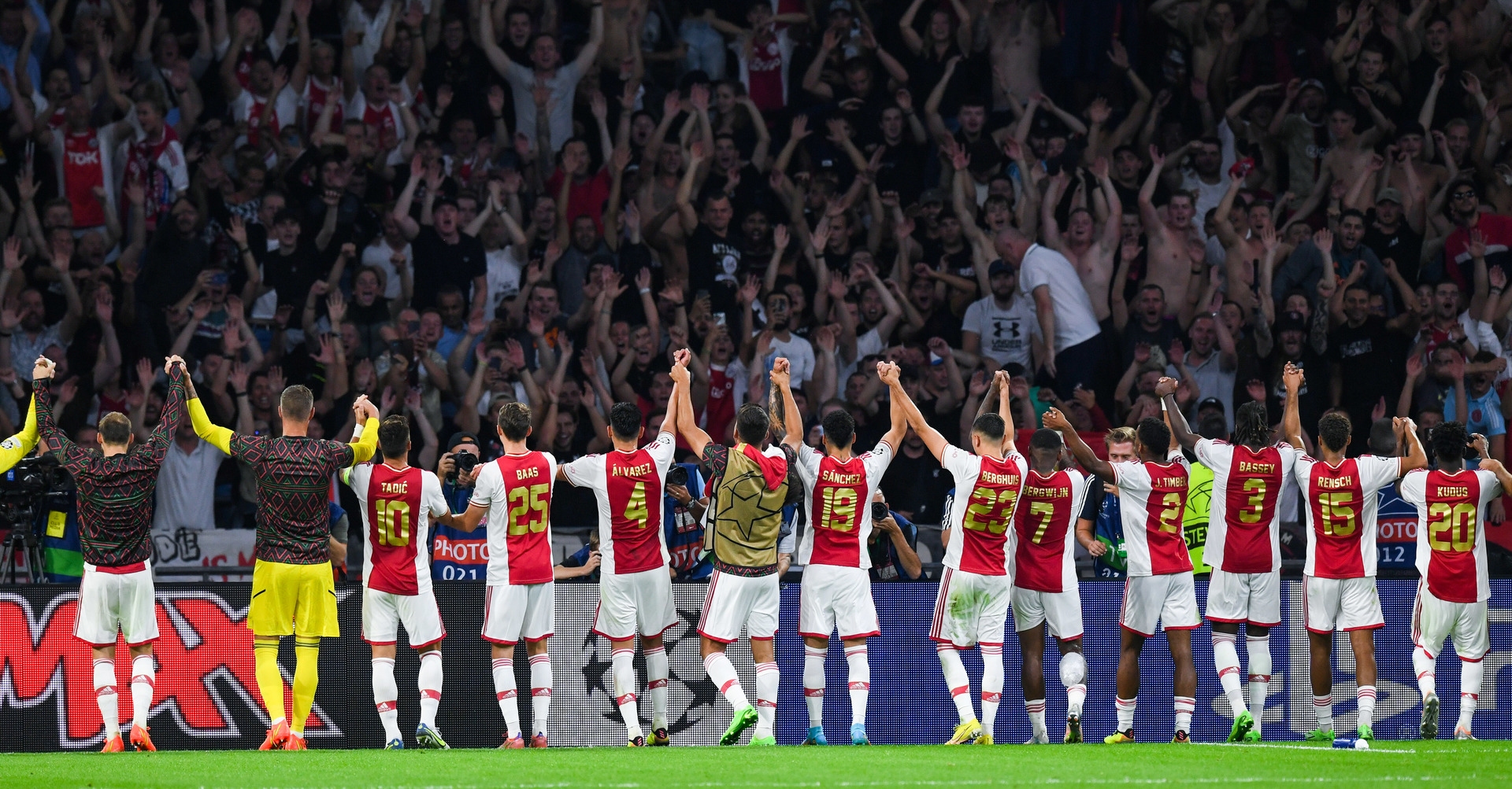  Ajax players celebrate with their fans at full time. 
