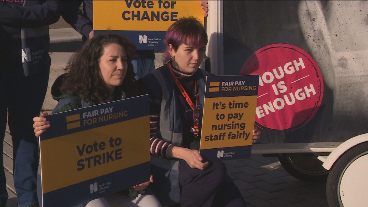 Union members are see holding a demonstration encouraging people to vote for the strike