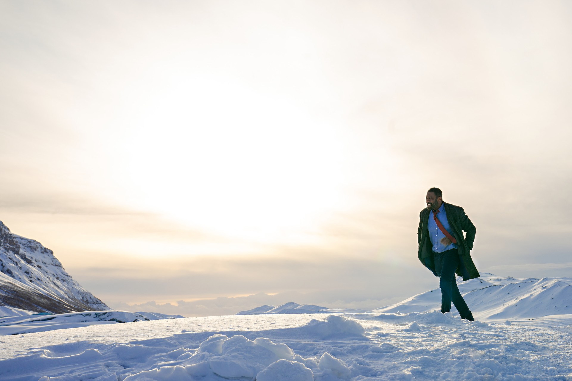 Other images show DCI Luther grimacing as he walks across a mountainous snow-covered landscape.