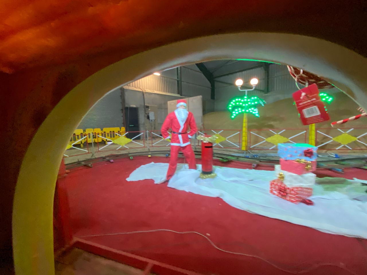 Images showed a mannequin without hands dressed as Santa, flanked by a post box, palm tree lights, and metal barriers. 