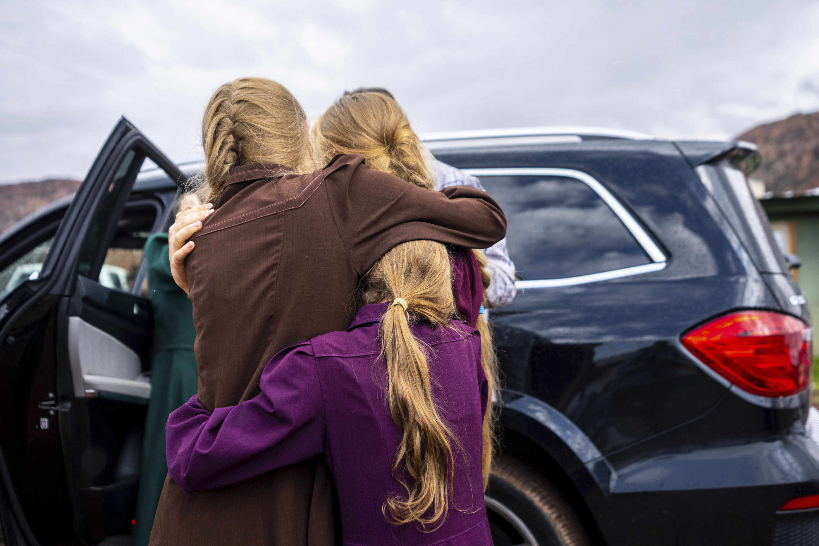 Three girls embrace before they are removed from the home of Samuel Bateman, following his arrest in Colorado City, Arizona, in September.