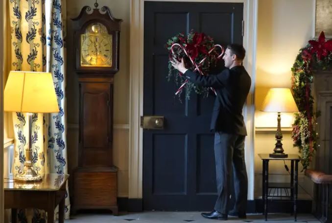 House butler Michael Russell checks the candy cane decorations on the door.