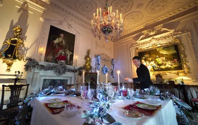 Michael Russell lights a candle in the Pink Dining Room.