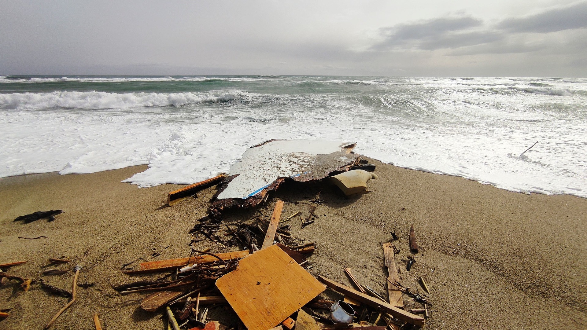 The wreckage from a capsized boat washes ashore at a beach near Cutro.